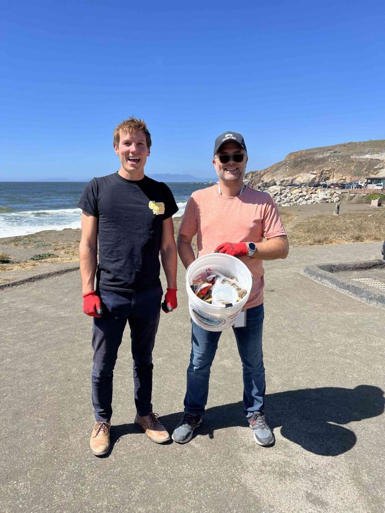 Two adult volunteers show off the trash and debris they collected