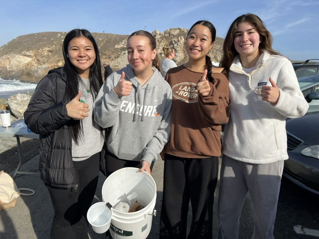 Four teen volunteers pose at a beach cleanup