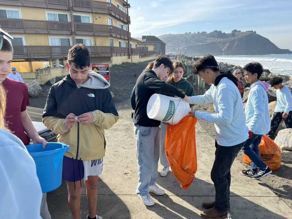 Students sort trash picked up at a beach cleanup