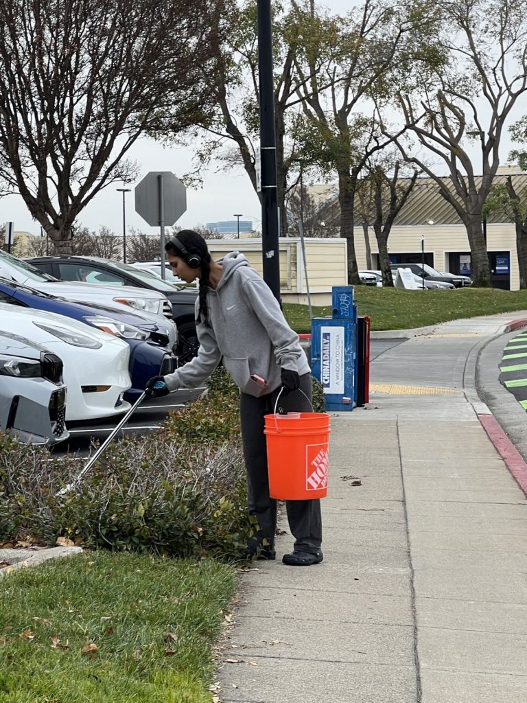 A young volunteer picks up trash at a PBC cleanup event