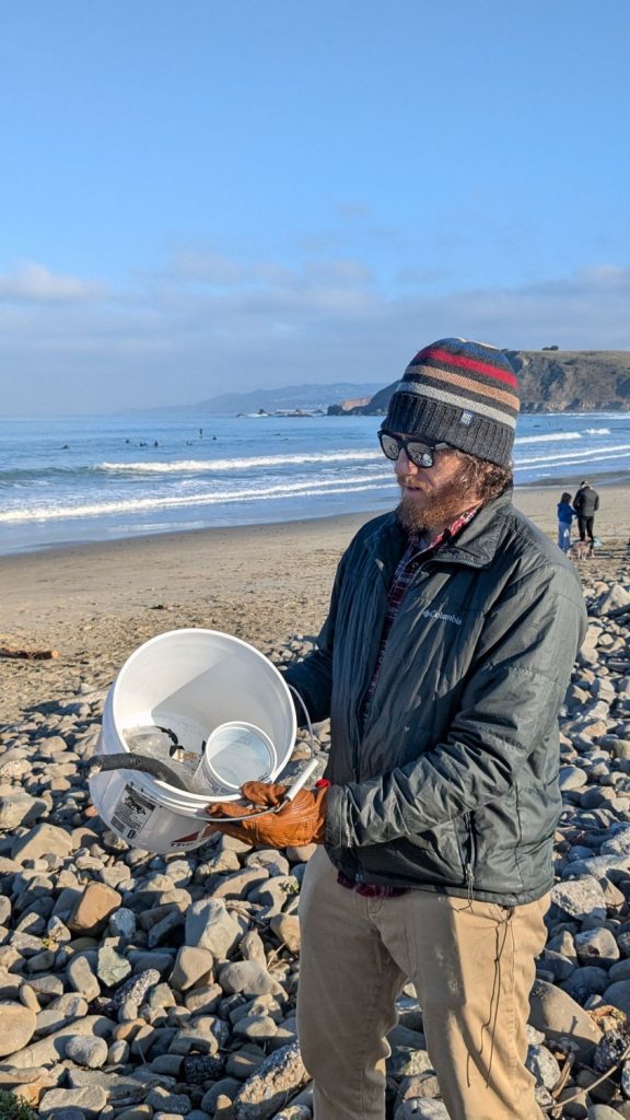 A volunteer shows off the trash he collected