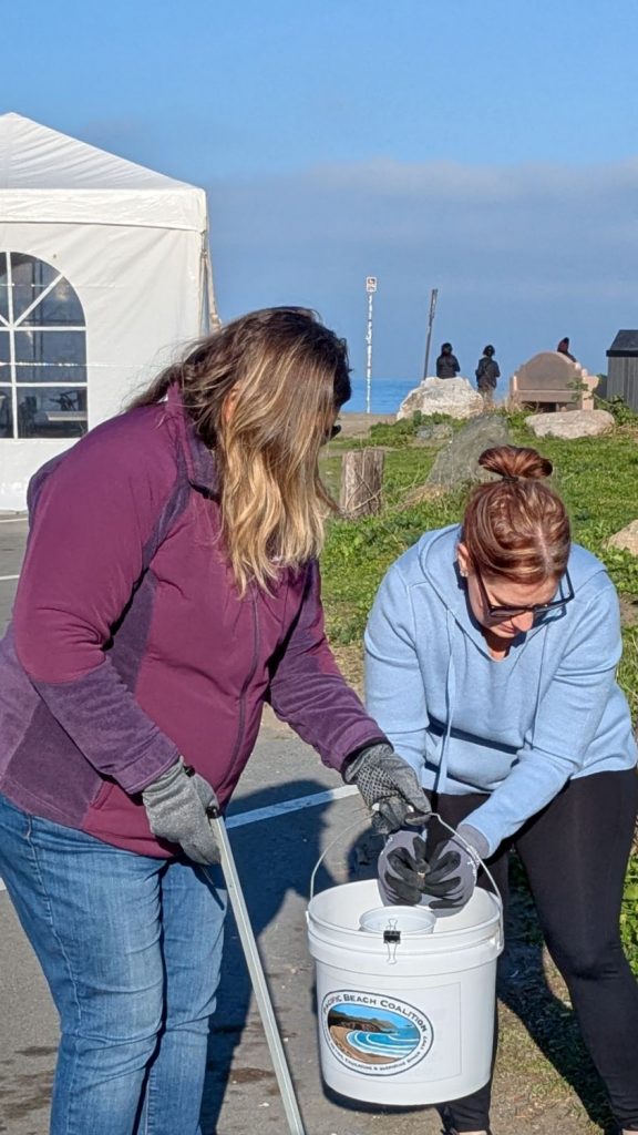 Two volunteers pick up trash