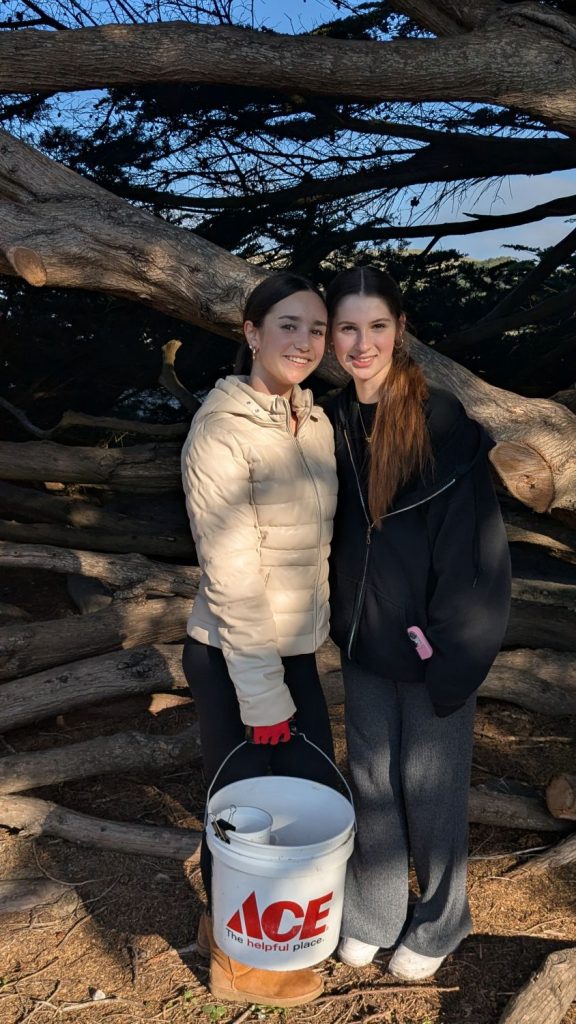 Two young volunteers at PBC's 28th Annual Beach Planting and Cleanup pose under a cypress tree