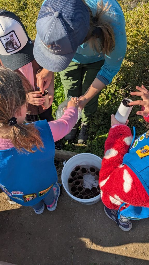 Young volunteers at PBC's 28th Annual Beach Planting and Cleanup prepare poppy seeds