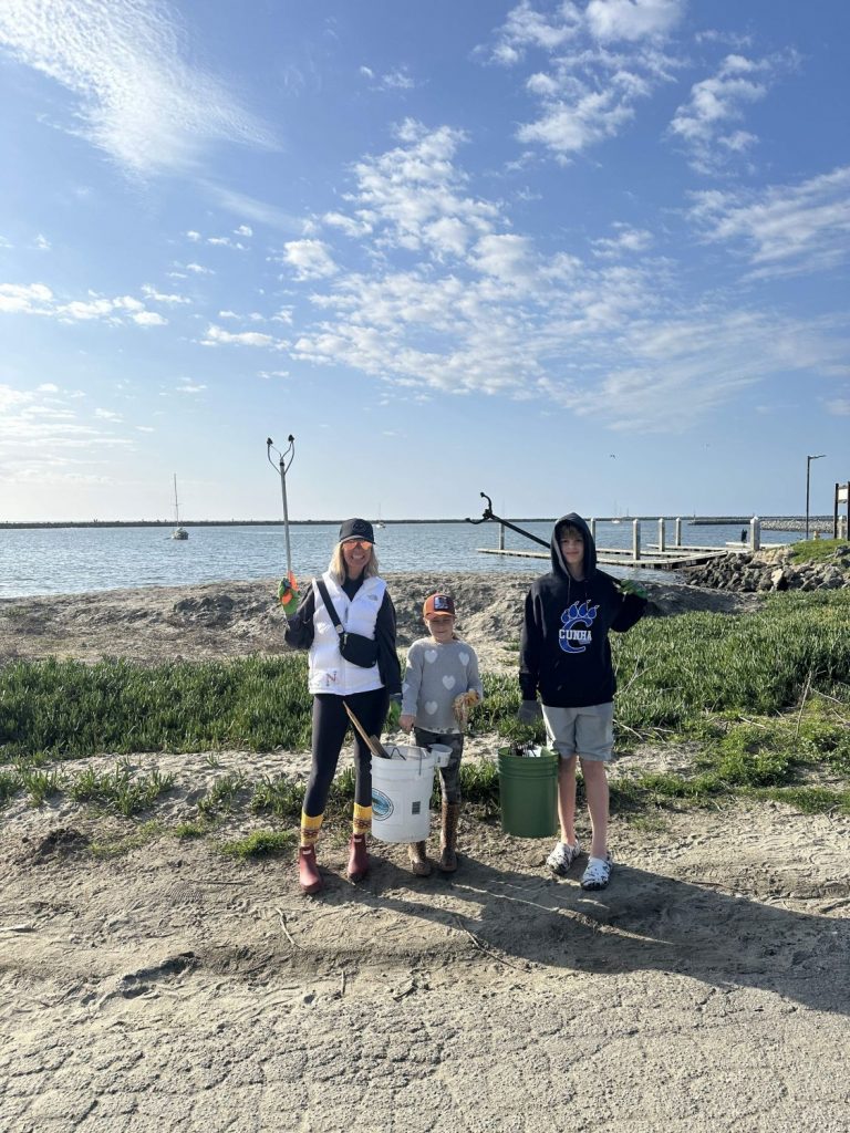 A family poses with their garbage pickup sticks and buckets