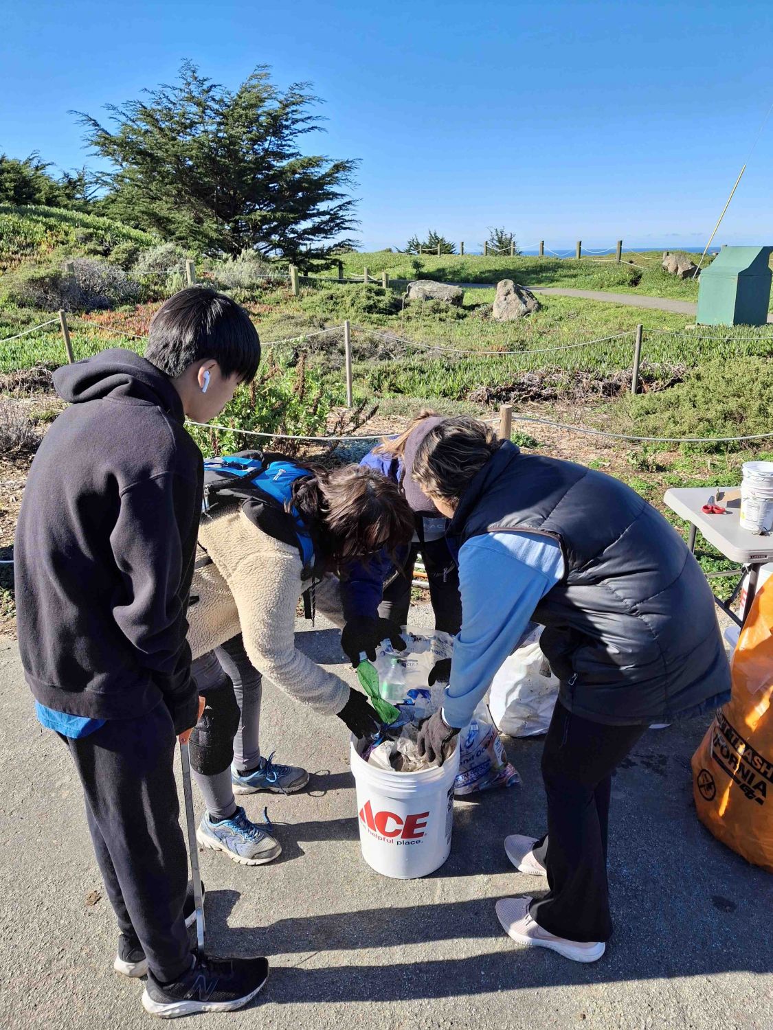 A group of volunteers sort through the trash they collected from a February 2025 PBC cleanup